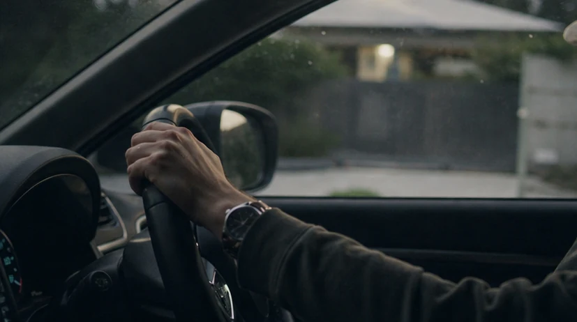 A hand on the steering wheel at the end of the workday